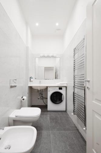 a bathroom with a toilet sink and a washing machine at Numa Milan Loreto in Milan