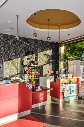 a fast food restaurant with a red counter at The Originals Résidence, Grenoble Université in Saint-Martin-dʼHères