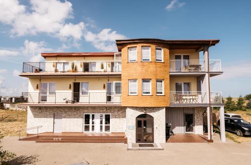 a large house with a car parked in front of it at Apartamenty Baltyckie in Władysławowo