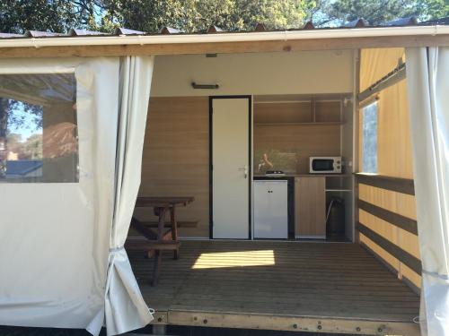 a screened in porch of a house with a kitchen at CAMPING Bassin Arcachon - LES GOELANDS in Arès