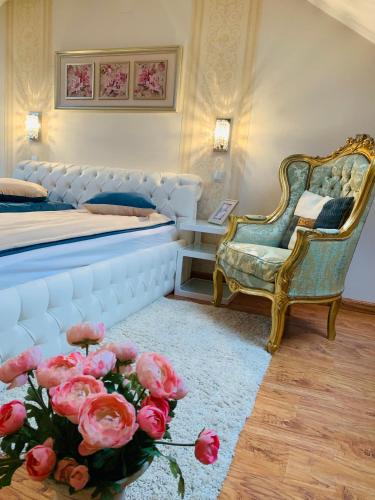 a bedroom with a bed and a chair and roses at Casa Central Luxury in Oradea
