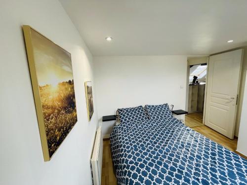 a bedroom with a bed and a painting on the wall at Appartement Oasis de Confort in Tourcoing