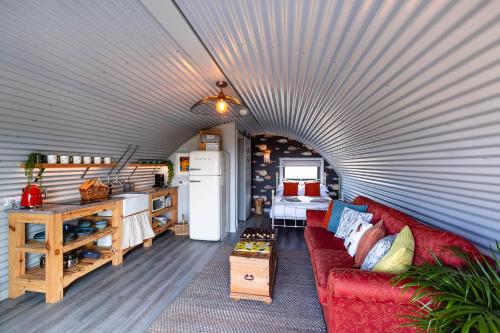 a living room with a red couch in a garage at The Bee Pods in Rossnowlagh