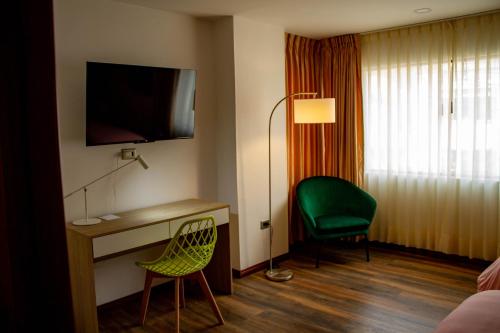 Habitación de hotel con escritorio y silla verde en Hotel Boutique Quinta Camacho, en Bogotá