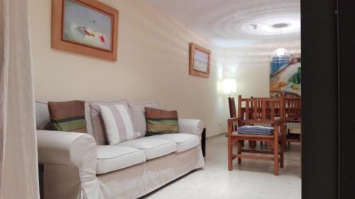 sala de estar con sofá blanco y mesa en Holiday Paraiso, en Sant Antoni de Calonge