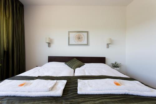 1 dormitorio con 1 cama con 2 toallas en Penzion U VINAŘSTVÍ ŠABATA, en Zaječí