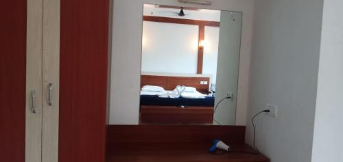 a mirror in a room with a bed in a bedroom at Hotel Exotica Squares in Neil Island