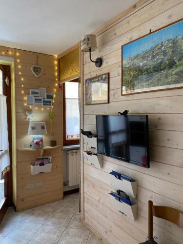 un soggiorno con TV su una parete in legno di Genziana C2 interno 32 a Prato Nevoso
