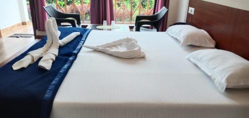 a large white bed with two white pillows on it at Hotel Exotica Squares in Neil Island