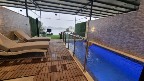 a balcony with chairs and a swimming pool at Grande Beach in Al Khīrān