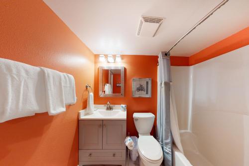 an orange bathroom with a toilet and a sink at Clearwater II in Gulf Shores
