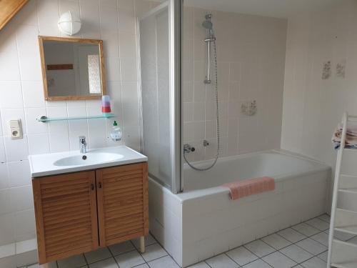La salle de bains est pourvue d'une baignoire, d'un lavabo et d'une douche. dans l'établissement Gästehaus zum Georgenberg, à Goslar