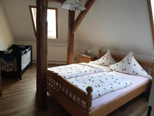 - une chambre dotée d'un lit en bois avec des draps et des oreillers blancs dans l'établissement Gästehaus zum Georgenberg, à Goslar