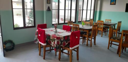 a dining room with a table and chairs with red napkins at HILLSCAPE in Cherrapunji