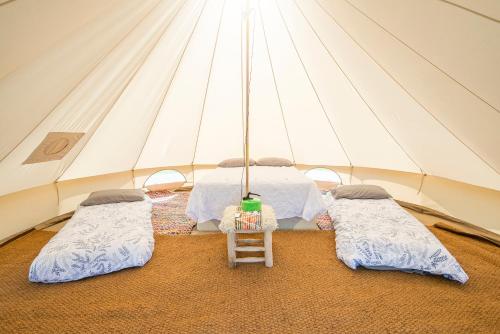 una habitación con 3 camas en una tienda de campaña en Parc Maerdy Glamping Holidays, en New Quay