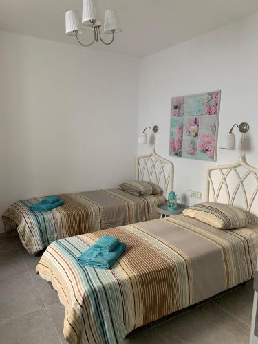 two beds in a hotel room with towels on them at Casa Acqua in Playa Honda