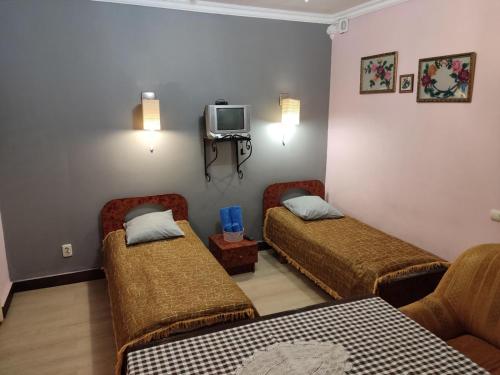 a hotel room with two beds and a tv at Готель-Маєток in Luts'k