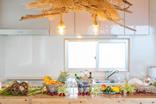 a kitchen with a counter with fruits and vegetables at SEA VIEW HOUSE KIRA KIRA HINANO in Nanjo