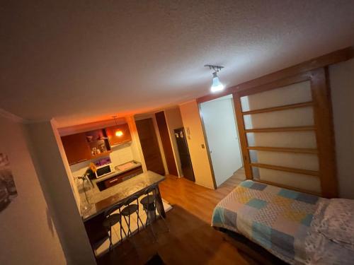 - Vistas a un dormitorio con cama y cocina en Departamento a pasos de Mall Plaza, en Antofagasta