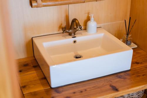a white sink in a bathroom with a wooden floor at SEA VIEW HOUSE KIRA KIRA HINANO in Nanjo