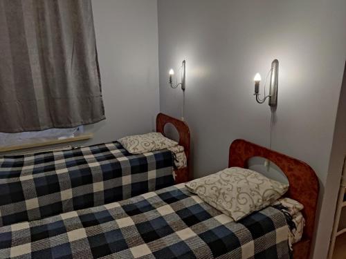 two twin beds in a small room with lights at Готель-Маєток in Luts'k