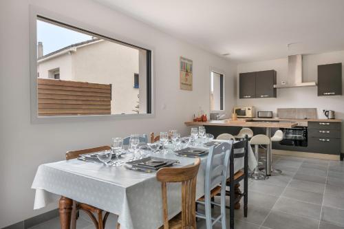- une salle à manger avec une table et des verres à vin dans l'établissement Maison récente en bord de mer - 15m de la plage, à Saint-Michel-Chef-Chef
