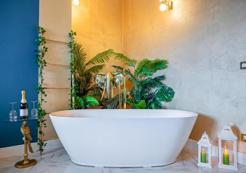 a white bath tub in a bathroom with plants at JUNGLE SUITE --- VASCA in camera in Turin