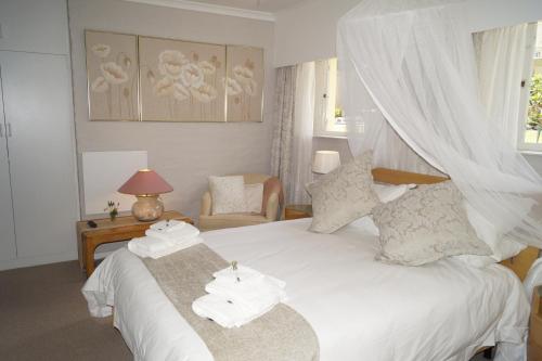 a bedroom with a bed with towels on it at Valentines Hermanus in Hermanus