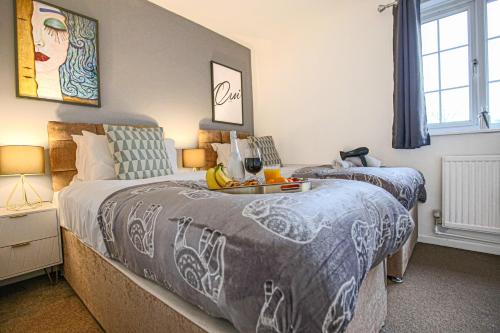 Un dormitorio con 2 camas y una mesa con fruta. en Petworth House - Central Milton Keynes - Smart TVs, Pool Table, Garden and Free Parking by Yoko Property, en Milton Keynes
