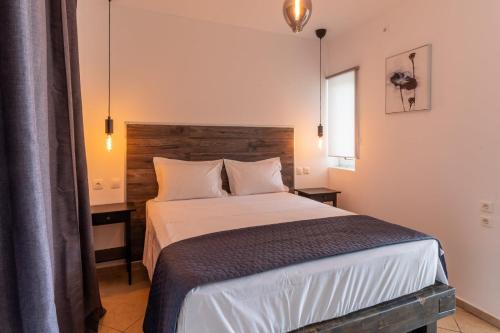 - une chambre avec un grand lit et une tête de lit en bois dans l'établissement Veranda 2-Guest Apartment, à Litochoro