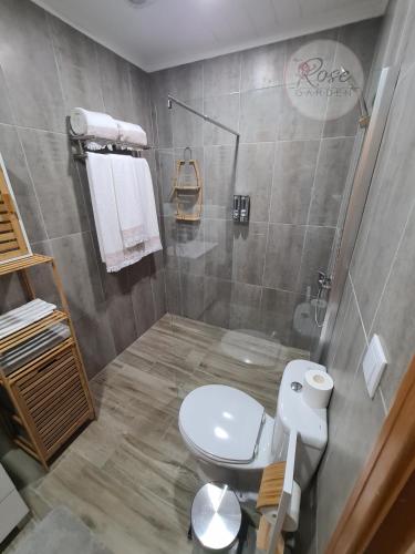 a bathroom with a white toilet and a shower at Lucy's Rosegarden in Urzelina