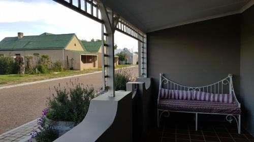 a bench sitting on a porch with a window at Buchu & Num-num in Stanford