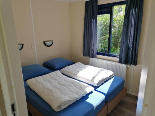 een slaapkamer met 2 bedden en een raam bij G06 Veldkamp Epe geschikt tot 4 personen in Epe