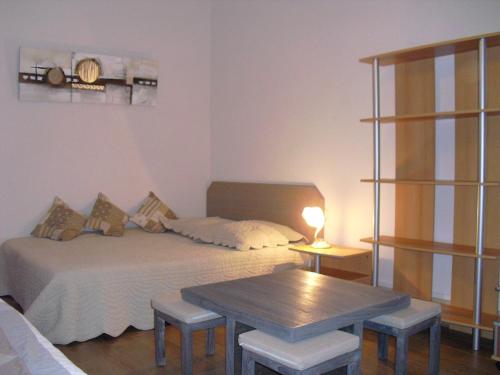 een slaapkamer met een bed en een tafel met krukken bij ANNECY COQUET MEUBLE t2 ENTRE STATION SKI ET LAC in Annecy