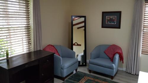 a room with two chairs and a desk and a mirror at Buchu & Num-num in Stanford