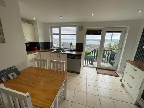 uma cozinha com uma mesa e vista para o oceano em Superb base for exploring Cornwall and Plymouth em Saltash