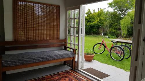 a porch with a bench and a bike outside at Buchu & Num-num in Stanford