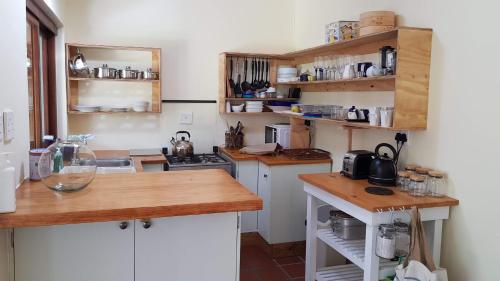 a kitchen with white cabinets and wooden counter tops at Buchu & Num-num in Stanford