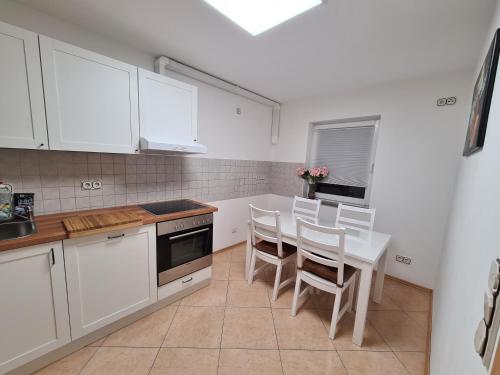 a kitchen with white cabinets and a table and chairs at 3-Zimmer Ferienwohnung Biggesee Sauerland nahe Olpe in zentraler, ruhiger Lage in Drolshagen