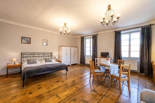 a bedroom with a bed and a table and chairs at Penzion Thallerův Dům in Český Krumlov