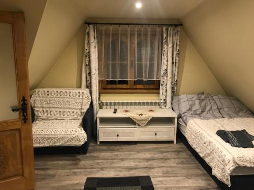 sypialnia z 2 łóżkami i oknem w obiekcie Apartament Groń w mieście Kościelisko