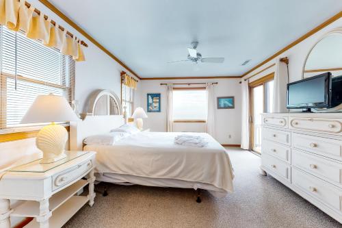a white bedroom with a bed and a tv at Elusive Day Dream #43-B in Buxton