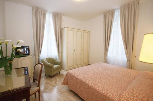 瓦拉澤的住宿－Hotel Villa Elena，一间卧室配有一张床、一把椅子和电视