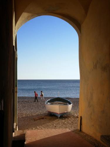 een boot op het strand met mensen op de achtergrond bij Hotel Villa Elena in Varazze