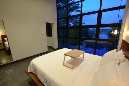 a small wooden stool sitting on a bed in a bedroom at The River Bank, Jinja in Jinja