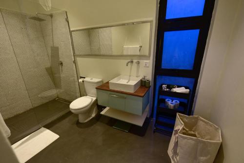 a bathroom with a toilet and a shower and a sink at The River Bank, Jinja in Jinja