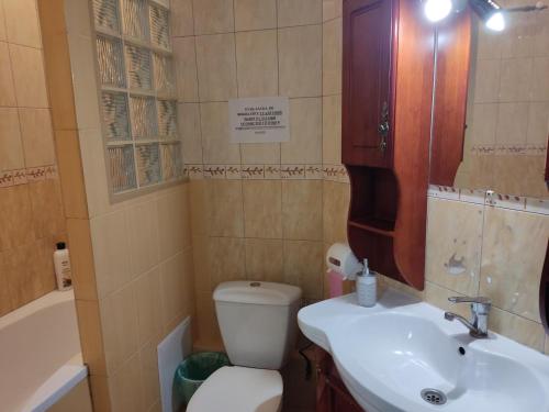 a bathroom with a toilet and a sink and a tub at Готель-Маєток in Luts'k