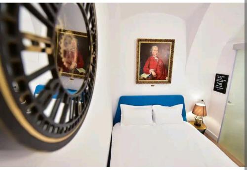 a bedroom with a bed and a framed picture of a man at Brukenthal Studio Sibiu in Sibiu