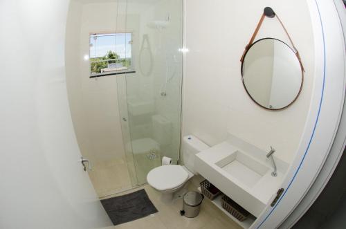 La salle de bains est pourvue d'une douche, de toilettes et d'un miroir. dans l'établissement Apto Nantes com Vista pro Beto Carrero World, à Penha