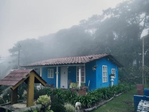 a blue house with a mountain in the background at Hospedaje Santaelena -chalets de montaña- in Santa Elena